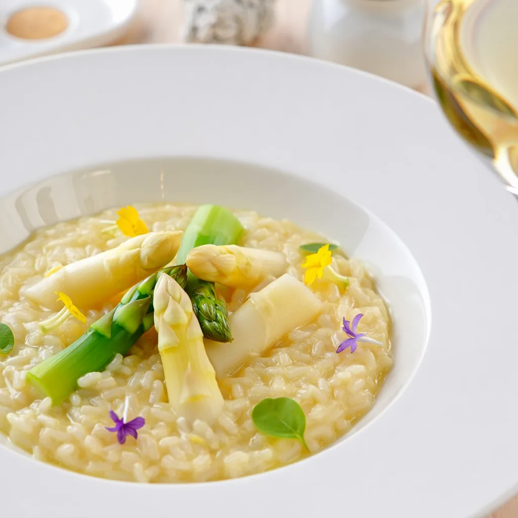 Assiette de risotto crémeux garni de pointes d'asperges vertes